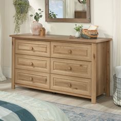 a wooden dresser sitting in front of a mirror