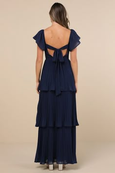 Everyone will instantly notice your sensational sense of style when you strut in wearing the Lulus Notorious Charm Navy Blue Pleated Flutter Sleeve Maxi Dress! Airy, pleated woven chiffon shapes this gorgeous dress that features a lightly gathered bodice with a sweetheart neckline and long sashes that secure atop an otherwise open back, framed by fluttery short sleeves (with elastic at the shoulders). The high, fitted waist tops a flowy, tiered A-line skirt that cascades down to a sweeping maxi Formal Dresses Floor Length, Greek Blue Bridesmaid Dresses, Navy Blue Dresses Long, Long Navy Blue Dress Outfit Casual, Navy Wedding Bridesmaid Dresses, Bridesmaid Dresses Blues, Floral Blue Bridesmaid Dresses, Long Sleeved Dress Formal, Royal Blue Wedding Guest Dress