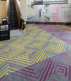 an escalator and colorful carpet in a building