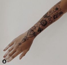 a woman's arm with flowers on it and an intricate design in the middle