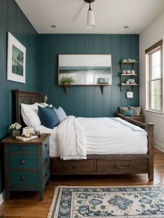 a bedroom with teal walls and white bedding, blue rugs and wooden furniture