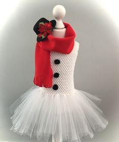 a white tutu skirt and red scarf on a mannequin