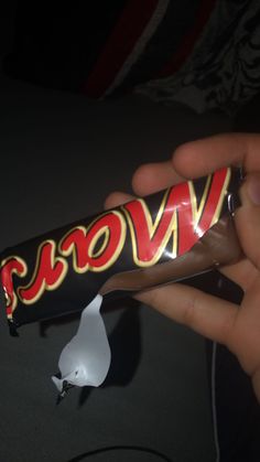 a hand holding a bar of chocolate with the word won't on it in red and yellow