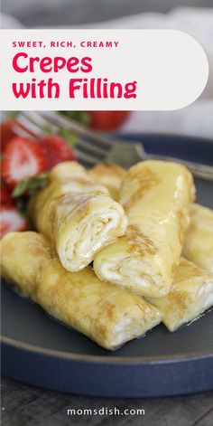 crepes with filling on a blue plate next to strawberries and a fork