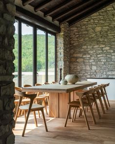 a dining room table and chairs in front of large windows