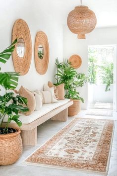 a living room filled with lots of potted plants next to a white couch and rug