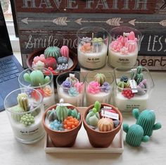 there are many small pots with cactus decorations on the table