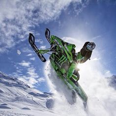 a snowboarder is in mid air doing a trick on his board while going down a snowy hill