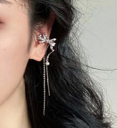 Sparkling no piercing silver ribbon ear cuff climber, with pearl and rhinestone dangles. Stylish punk street wear style, super chic and edgy. No ear hole necessary, easy to wear and adjust. Delicate cubic zircon paved on cute silver ribbon. Absolutely unique add on to your everyday outfit! , 💎 Features: ♥ Material: Silver plated copper ♥ Main stone: Faux pearl ♥ Side Stone: Rhinestone ♥ Adjustable ear cuff, no ear hole needed ♥ Sold as 1 piece 💎 Details: ♥ Approximate Measurements: - Length: 7.5 cm - Width: 2.3 cm ♥ Lightweight, easy to wear ♥ Nickel/Lead Free, Hypoallergenic, good for sensitive skins 🎁 Packing & Shipping: ♥ All our jewelry will be shipped with beautiful gift wrap packaging ♥ Handwrite gift notes/cards available upon request ♥ SAME DAY& FREE US Domestic Shipping availab Elegant Single Ear Climber For Parties, Sterling Silver Dangle Ear Cuff For Party, Elegant Adjustable Wrap Earrings For Party, Elegant Cartilage Earrings For Party, Sterling Silver Ear Climbers For Party, Sterling Silver Single Ear Cuff For Party, Party Ear Cuff With Ear Wire, Elegant Drop Cartilage Earrings For Party, Silver Dangle Ear Cuff For Party