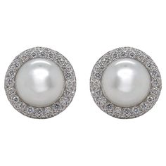 Earrings contain two 12.8mm South Sea Pearls and 120 round brilliant diamonds surrounding within a pave style halo, approximately 3.00tcw. Diamonds are near colorless and SI1 in clarity, excellent cut. Earrings have a French clip post closure, all in 18k white gold. All of our pieces are packaged carefully and accompanied by a Pico box to keep your jewelry item safe. A complimentary appraisal can be sent after 5 days of purchase via air mail or email; please inquire. Diamond Cluster Round Earrings For Evening, Diamond Cluster Earrings For Evening, Luxury Round Diamond Earrings With Sparkling Stones, Luxury Round Bridal Earrings With Halo Setting, Luxury Bridal Earrings With Pave Setting For Anniversary, Luxury Bridal Earrings With Pave Setting, Classic Formal Pearl Earrings With Pave Setting, Formal Bridal Earrings With Pave Setting, Luxury Diamond Pearl Earrings With Pave Setting