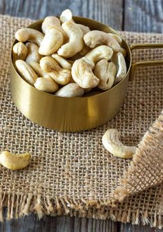 a metal bowl filled with cashews sitting on top of a burlock