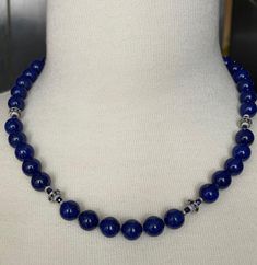 This gorgeous necklace of round lapis lazuli beads with sapphire and white gold accents is the epitome of style and sophistication! 10mm round, beautifully matched lapis with their high-polish and stunning royal blue color have been arranged with 18k white gold rondels, faceted blue sapphire beads and white gold rondels. The larger white gold rondels are set with tiny sparkling sapphires that complement the lapis perfectly, and the white gold accents have a lovely stardust finish, treating your eyes to a wonderful combination of sizes, shapes, color and textures. Hand strung on silk thread and finished with a 14k white gold clasp, this necklace is a great way to show off your sense of style and that undefinable look of understated, effortless elegance! Necklace measures 19 inches in length Elegant Beaded Lapis Lazuli Necklace, Elegant Single Strand Lapis Lazuli Beaded Necklaces, Elegant Single Strand Lapis Lazuli Beaded Necklace, Sapphire Lapis Lazuli Necklace With Polished Beads, Elegant Lapis Lazuli Necklace With Faceted Beads, Sapphire Polished Beads Lapis Lazuli Necklace, Elegant Lapis Lazuli Necklace With Polished Beads, Elegant Blue Lapis Lazuli Beaded Necklaces, Sapphire Lapis Lazuli Beaded Necklace