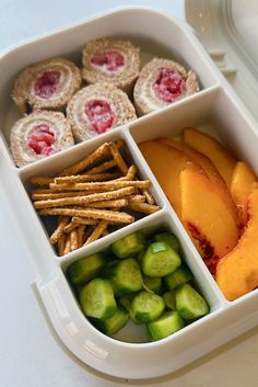 a white container filled with fruit and crackers