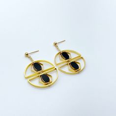 The earrings are light weight and are made to rotate and reposition with movement. The earrings consist of black oval shaped beads. They are new old stock vintage German glass beads that are framed with 24K gold. The beads were hand pressed during the 1920s-1960s. No two beads are exactly alike. These beads are no longer in production thus making them rare and collectible.  Due to the nature of this jewelry, it is unique.  Product Detail:  24K gold edge German vintage glass Bead 24K gold-plated brass metals gold-filled finding and ear wire   *Our jewelry has maximum protection for anti-tarnish and is made for extended wear. You may gently polish your jewelry with a soft jewelry cloth using water and a little soap to restore their brighter finish. Do not rub the vintage glass beads too hard Modern Metal Earrings For Evening, Modern Metal Evening Earrings, Modern Oval Metal Earrings, Formal Circular Metal Earrings, Gold Spherical Metal Earrings, Modern Gold Plated Oval Earrings, Modern Teardrop Stainless Steel Earrings, Metal Round Earrings As Gift, Modern Round Gold Plated Earrings