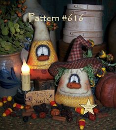 two scarecrows are sitting next to each other with candles in front of them