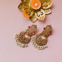 Nauratan timelessness that carry distinct style, intricacy and craftsmanship of a bygone era! A talismanic pair studded with ethereal stones and the grace of pearl moti along with the radiance of traditional and aesthetic identity. Approximate earrings length is 4". Gold-plated on high-quality brass as base metal. Made by order. Kindly allow 5-7 weeks for the delivery of this item. For custom or urgent requests, please contact support@alacouture.com. *Please Note: The multi-colored beadwork migh Elegant Meenakari Jewelry For Rituals, Traditional Bridal Earrings With Intricate Design For Navratri, Temple Jewelry Stone Work Danglers For Celebration, Festive Stone Work Temple Jewelry Earrings, Temple Jewelry Danglers With Stone Work For Celebration, Multicolor Temple Jewelry Bridal Earrings With Intricate Design, Elegant Multicolor Jewelry For Rituals, Fusion Style Chandbali Pearl Earrings With Meenakari, Fusion Chandbali Jewelry For Celebrations