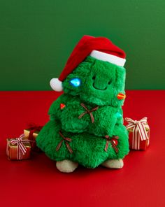 a green stuffed christmas tree sitting on top of a red table