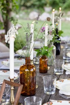 an image of a table setting with candles and vases on the table in front of it