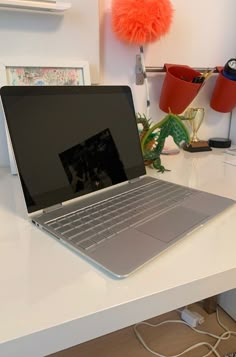 an open laptop computer sitting on top of a white desk