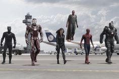 several superheros are standing in front of an airplane on the tarmac at an airport