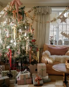 a decorated christmas tree in a living room with presents under it and other holiday decorations