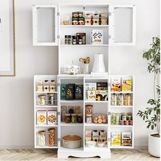 a white shelving unit filled with lots of food and condiments next to a potted plant