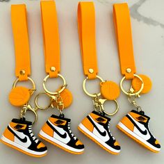 four orange lanyards with black and white shoes on them, one has a basketball shoe keychain