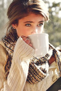 a woman holding a coffee mug in her hand