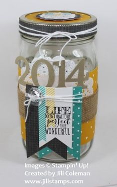 a mason jar filled with lots of paper and some tags on the top of it