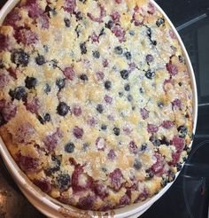 a pie with blueberries and other toppings in a pan on top of a stove