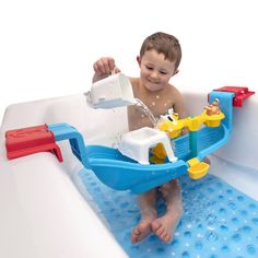 a young boy playing in an inflatable bathtub with water pouring from the faucet