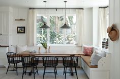 a dining room table with four chairs and a bench in front of a window that is open to the outside