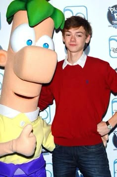 a man standing next to a cartoon character with his arm around another person's shoulder