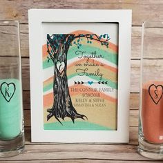 two shot glasses sitting on top of a table next to a picture frame with a tree