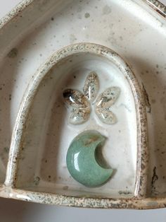 an old ceramic dish with a flower decoration on the side and a crescent in the middle