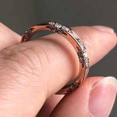 a close up of a person's hand holding a wedding ring