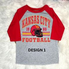 Get your little one ready for game day with this stylish KC Chiefs raglan t-shirt! Perfect for young fans, this comfy and durable shirt features their favorite team spiritwear. Whether cheering from home or at the stadium, they'll love showing off their Chiefs pride in this fun and sporty design. Available in various sizes for the perfect fit! Team-colored Baseball Jersey With Graphic Print For Game Day, Team-colored Graphic Print Baseball Jersey For Game Day, Red T-shirt With Name Print For Game Day, Red Team Spirit T-shirt With Name Print, Fan Apparel Baseball Jersey For Game Day, College Raglan Sleeve T-shirt With Letter Print, College Raglan Sleeve T-shirt With Graphic Print, Letter Print Raglan Sleeve T-shirt For College, Game Day Baseball Jersey With Graphic Print