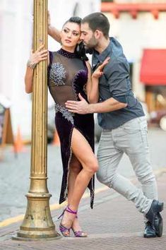 a man standing next to a woman near a pole