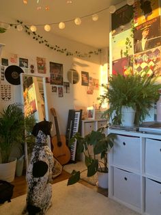 a dog sitting on the floor next to a potted plant in a living room