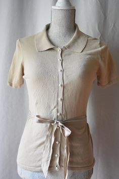 "Sophisticated and feminine, vintage, beige button up collared sweater blouse with lovely pearl buttons. With short sleeves and a nice matching sash to tie around the waist. There is some stretch to the fabric. Women's size S. Bust: 34\" Waist: 30\" Length: 23: Tag: East 5th Material: 57% cotton 43% rayon" Collared Sweater, Shirt Business, Pop Style, Collar Blouse, Pearl Buttons, Casual Attire, Sweater Blouse, Womens Clothing Tops, Business Casual