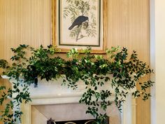 a living room filled with furniture and a fire place covered in greenery next to a painting on the wall