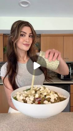 a woman pouring dressing into a large bowl