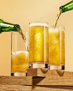 two glasses filled with beer being poured into them