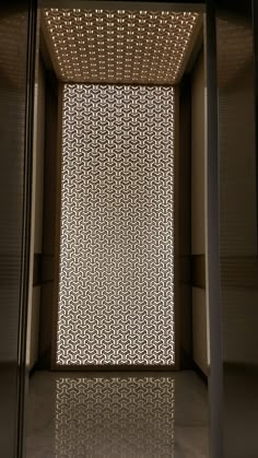 an empty room with a light shining through the window and flooring on the walls