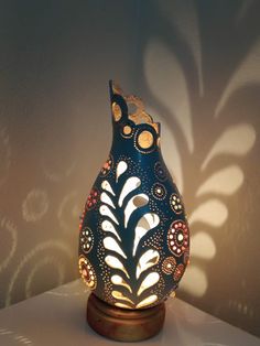 a blue vase sitting on top of a table next to a shadow cast by a wall