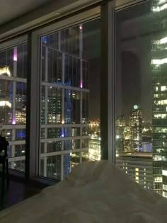 a bedroom with a view of the city at night