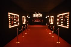 a red carpeted hallway with lights on the walls