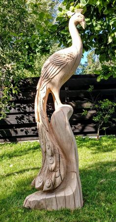 a bird statue sitting on top of a lush green field