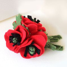 a close up of a red flower on a white surface