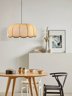 a wooden table with two chairs and a light fixture hanging over it's head